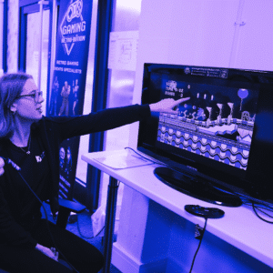 Games student pointing to computer screen with game on it