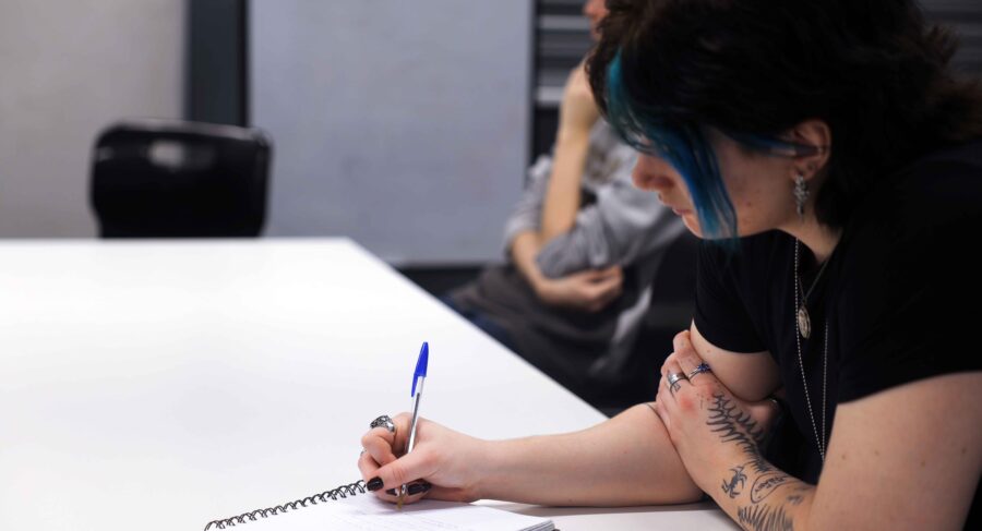 MetStudios Brighton student seated writing on a piece of paper
