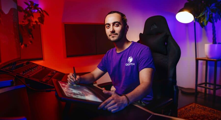 MetStudios Game design student, smiling, sat in front of computer working