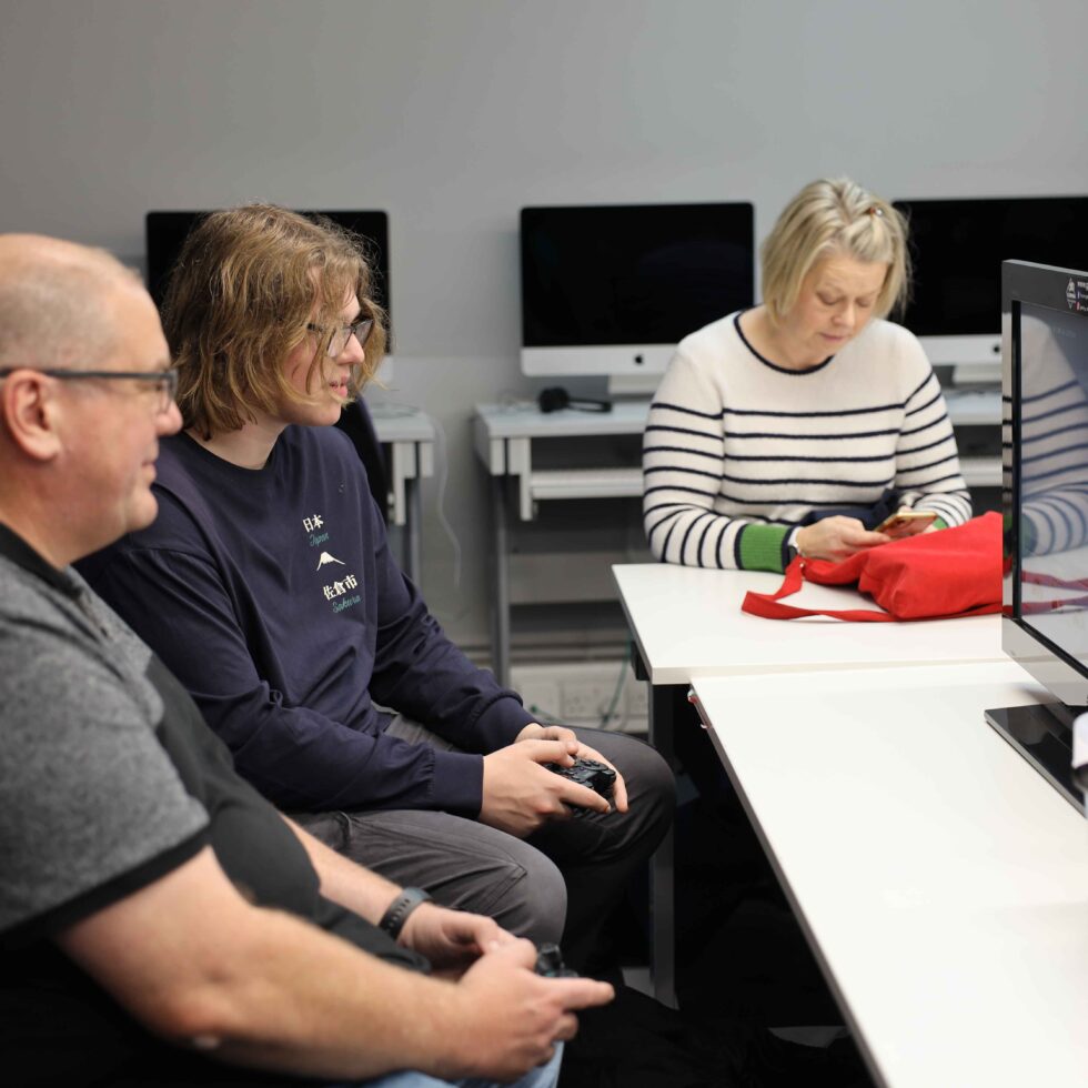 pupils and parents playing games on console in classroom at MetStudios